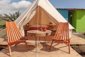 uma tenda com 2 cadeiras e uma mesa num pátio em Glamping Octli - Santuario de las Luciernagas X NANTLI LIVING em Nanacamilpa