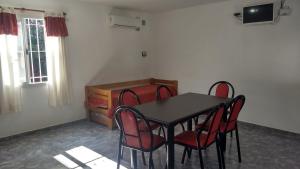a dining room with a table and red chairs at Cabañas Luna del Sur in Merlo