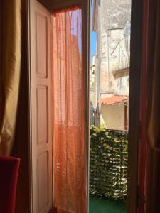 an open door with an orange curtain and a balcony at B&b Torretta San Giovanni a Corte in Sant'Agata de' Goti