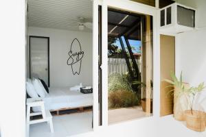 a guest house patio with a bed and a sliding glass door at Suyog Life Siargao in General Luna
