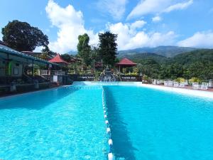 a swimming pool at a resort with mountains in the background at Inna Tretes Hotel & Resort in Prigen