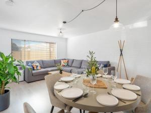 a dining room with a table and a couch at Bayswell by Experience Jervis Bay in Huskisson