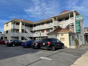 a parking lot with cars parked in front of a hotel at Sea Palace Motel in Seaside Heights