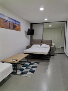 um quarto com duas camas e uma mesa em Berilo Deluxe Apartahotel em Barranquilla