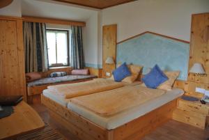 a bedroom with a large bed with blue pillows at Landhaus Neubauer - Zimmer in Millstatt