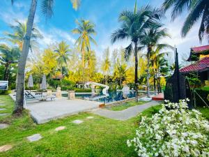 a park with palm trees and a swimming pool at Palm Galleria Resort-SHA Extra Plus in Khao Lak
