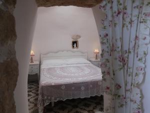 a bedroom with a white bed and two tables and two lamps at B&B Corallo in Capilungo