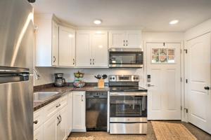 una cocina con armarios blancos y electrodomésticos de acero inoxidable en Cañon City Home 15 Mi to Royal Gorge Bridge!, en Canon City