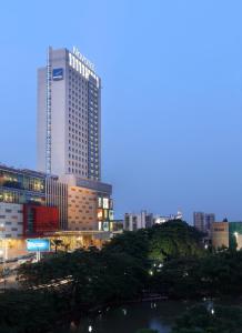 een skyline van de stad met een hoog gebouw en een rivier bij Novotel Tangerang in Tangerang