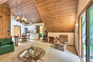 a living room with a wooden ceiling and a table at Charming Roan Mtn Cabin Across from Creek! in Roan Mountain