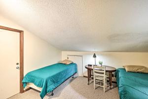 Un dormitorio con una cama y una mesa con una silla. en Charming Roan Mtn Cabin Across from Creek!, en Roan Mountain