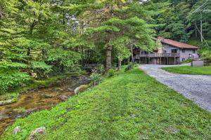 una casa con un camino de grava al lado de un río en Charming Roan Mtn Cabin Across from Creek!, en Roan Mountain