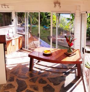 HaapuにあるHUAHINE Manta Lodge avec 4x4 optionnelの木製のテーブルのあるキッチンとリビングルーム