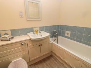 a bathroom with a sink and a bath tub at Groom's Cottage in Allanton +19 photos