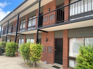 een appartementencomplex met een zwarte deur en ramen bij Ploughmans Motor Inn in Horsham