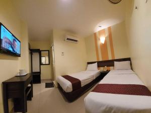 Habitación de hotel con 2 camas y TV de pantalla plana. en Sun Inns D'mind 3 Seri Kembangan, en Seri Kembangan