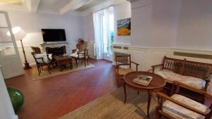 a living room with a table and chairs and a television at 1560- Domaine Des Cinq Jardins- A Magical and Authentic Mansion in Fuveau