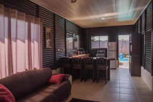 a living room with a couch and a kitchen at Cabaña El Monasterio in Fortuna