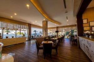 a restaurant with tables and chairs and a bar at Kristal Hotel Kupang in Kupang