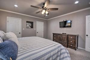 a bedroom with a bed with a ceiling fan and a tv at Stylish Home - Walk to Texas Tech University! in Lubbock