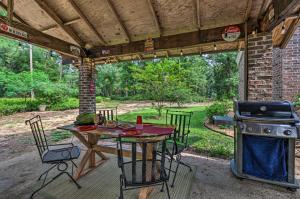 a table and chairs on a patio with a grill at Bonifay Estate with Spring-Fed Swimming Hole! in Bonifay