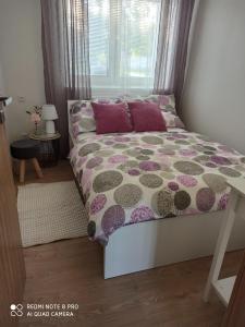 a bedroom with a bed with a purple and gray comforter at Familly Apartmens in Dolní Dunajovice