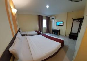 Habitación de hotel con cama grande y TV en Sun Inns D'mind 3 Seri Kembangan, en Seri Kembangan