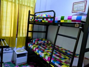 - une chambre avec 2 lits superposés et un lit coloré dans l'établissement Salam D'Mawar Homestay, à Sungai Coh