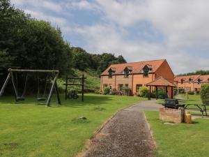 einen Park mit Spielplatz und ein Haus in der Unterkunft Fauna's Corner in Whitby