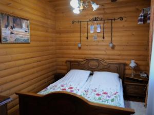 sypialnia z łóżkiem w drewnianym domku w obiekcie Sadyba Pochayiv w mieście Poczajów
