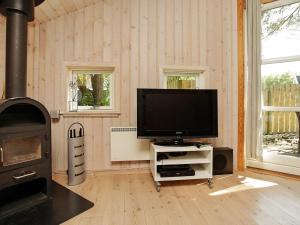 a living room with a television and a stove at 10 person holiday home in V ggerl se in Marielyst