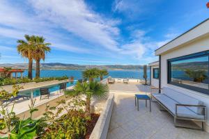 a house with a patio with a view of the water at Villa Sun and Sea in Trogir