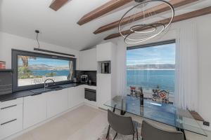 - une cuisine avec une table en verre et une vue sur l'océan dans l'établissement Villa Sun and Sea, à Trogir