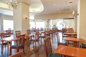 a dining room filled with wooden tables and chairs at Hotel Sankyo Fukushima in Fukushima