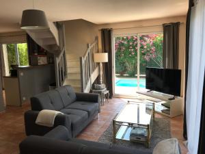 a living room with a couch and a tv at La maison de Virginie 6 a 12 personnes -300 m de la plage- vélos a disposition in Saint Cyprien Plage