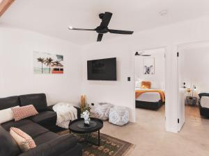 a living room with a couch and a ceiling fan at Poplar Villa - 1 Poplar Lane in Evans Head