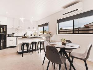 a kitchen and dining room with a table and chairs at Poplar Villa - 1 Poplar Lane in Evans Head +5 photos