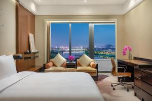 - une chambre avec un lit, un bureau et une grande fenêtre dans l'établissement Crowne Plaza Huangshan Yucheng, an IHG Hotel, à Huangshan