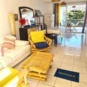 a living room with a couch and a table at Appartement spacieux à Bois des Nèfles, 70 m², piscine partagée in Le Bois de Nèfles +3 photos
