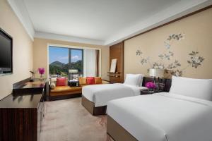a hotel room with two beds and a television at Crowne Plaza Huangshan Yucheng, an IHG Hotel in Huangshan
