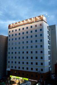 a hotel building with a sign on top of it at Candeo Hotels Ueno Park in Tokyo