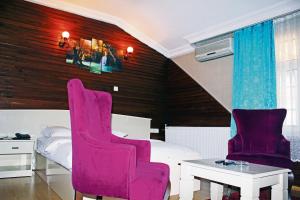 a bedroom with a pink chair and a bed at Bordo Hotel in Trabzon