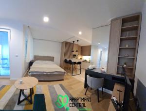 Il comprend une chambre avec un lit, un bureau et une cuisine. dans l'établissement Apartmani Central 4 & Free parking, à Vrnjačka Banja