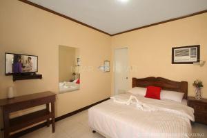 a bedroom with a bed and a table and a mirror at Ana Jean Lodging House in San Francisco