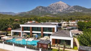 a resort with a swimming pool and mountains in the background at Güven Park Residance & Apart Hotel in Kemer