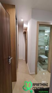 een hal met een badkamer met een toilet en een deur bij Apartmani Central 4 & Free parking in Vrnjačka Banja