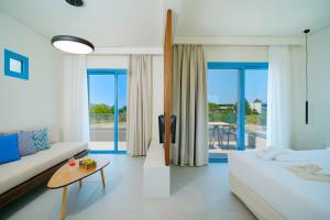 a bedroom with a bed and a couch and a table at Narciso Thassos Luxury Suites in Skala Prinou +76 photos