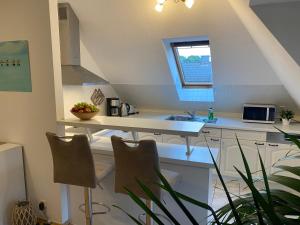 a kitchen with a sink and a counter with chairs at Ferienwohnung Bernsteinsucher städtische Bestlage in Ribnitz-Damgarten +5 photos