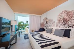 a hotel room with a large bed and a desk at Yam Suf by Isrotel Collection in Eilat