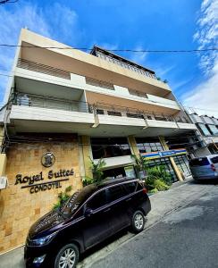 a black suv parked in front of a building at Royal Suites Condotel in Kalibo